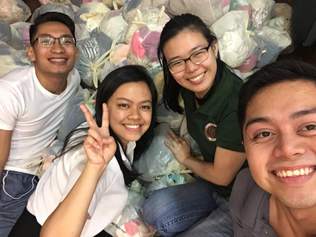 Student volunteers take a group picture after a well-spent night of repacking donations
