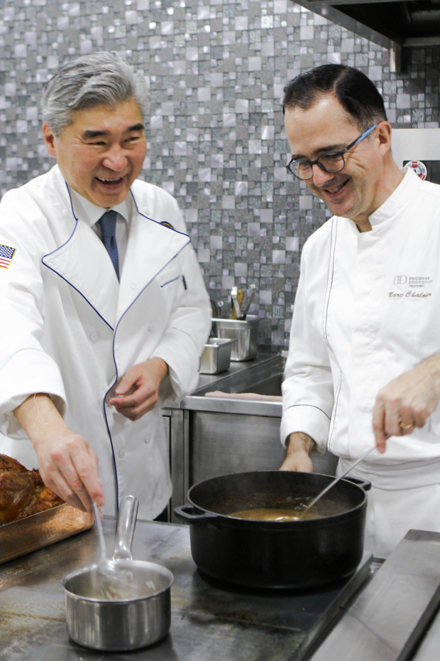 U.S. Ambassador to the Philippines Sung Kim helps cook the turkey for the Thanksgiving luncheon