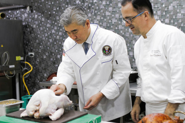 U.S. Ambassador to the Philippines Sung Kim helps cook the turkey for the Thanksgiving luncheon